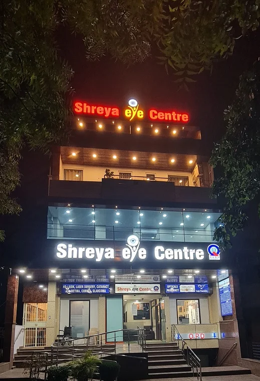 Front view of Shreya Eye Centre building illuminated at night, showcasing the hospital’s modern glass façade and entrance signage.